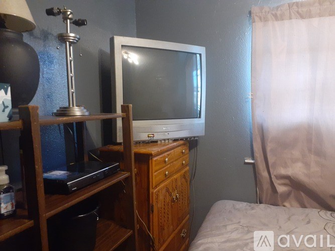 A small room with a television on a wooden cabinet.