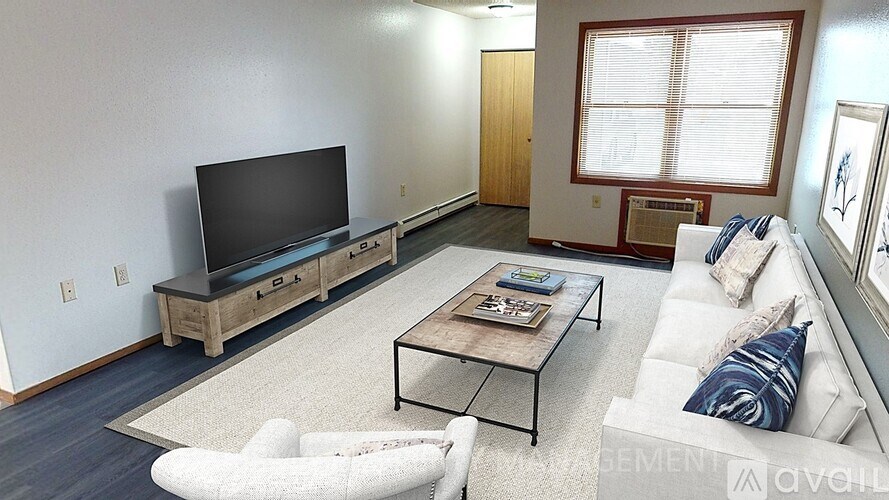 A living room with a white couch, a coffee table, and a flat screen TV.
