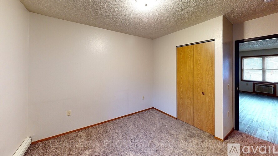 A room with a wooden door and carpeted floor.