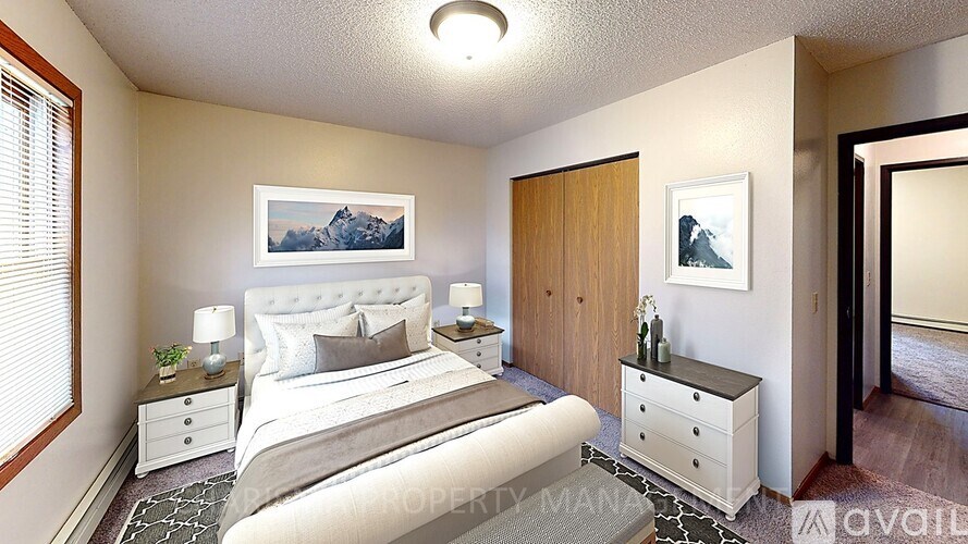 A bedroom with a large bed, two nightstands, and a painting on the wall.