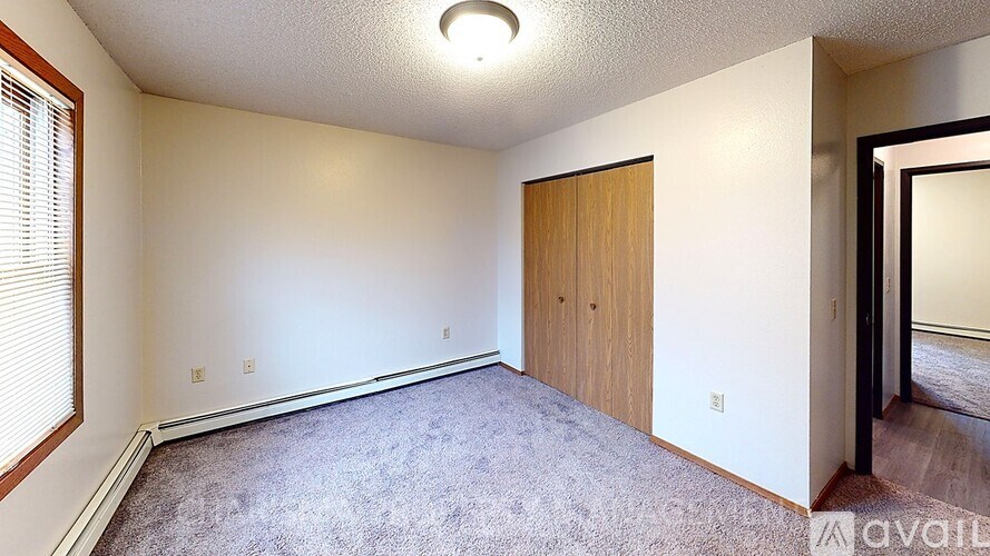 A room with a carpeted floor and a wooden door.