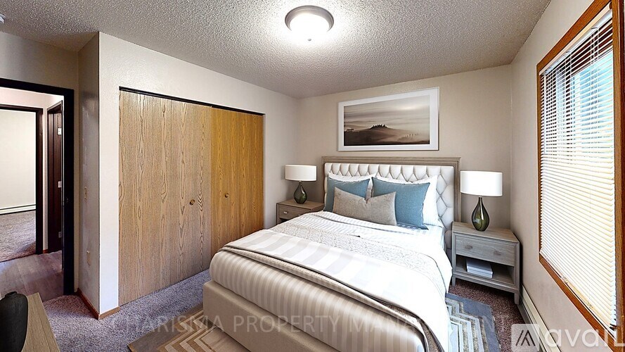 A bedroom with a large bed and a wooden door.