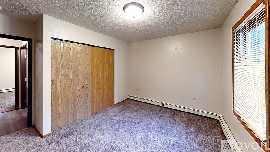 A room with a carpeted floor and a wooden door.