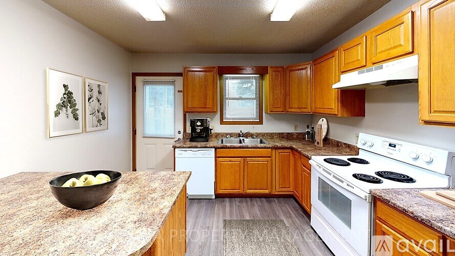 A kitchen with wooden cabinets and a granite countertop.