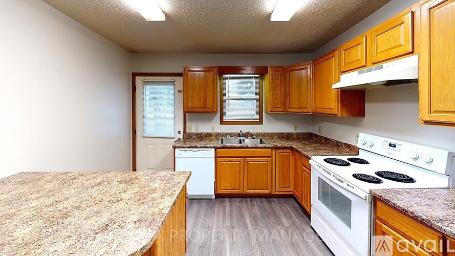 A kitchen with wooden cabinets and a white stove top oven.