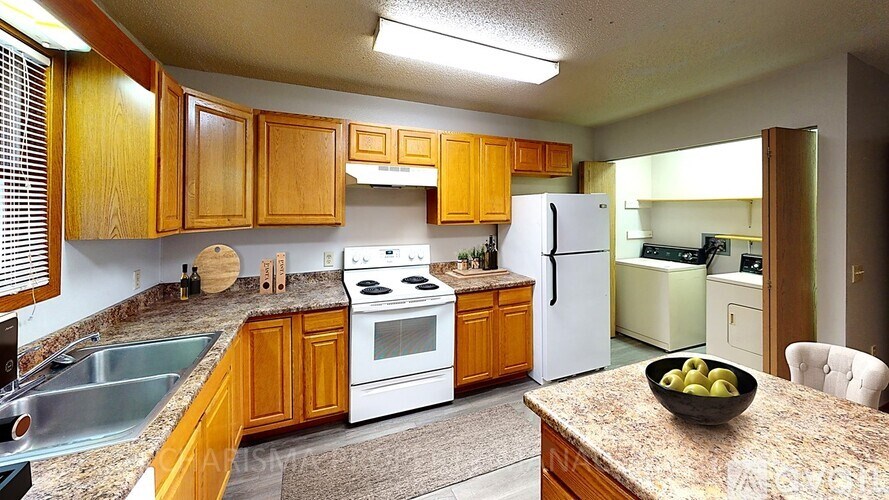 A kitchen with wooden cabinets and a granite countertop.