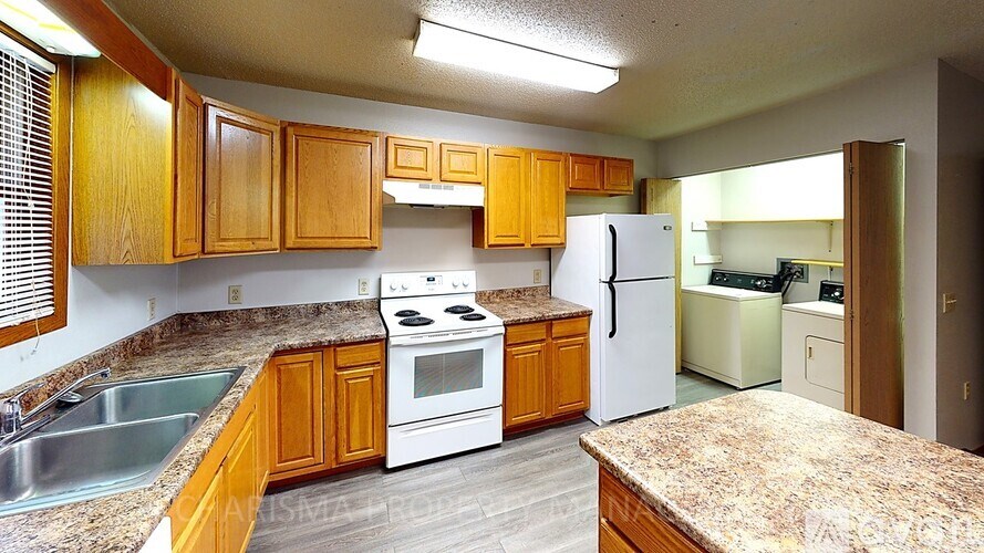 A kitchen with wooden cabinets and a granite countertop.