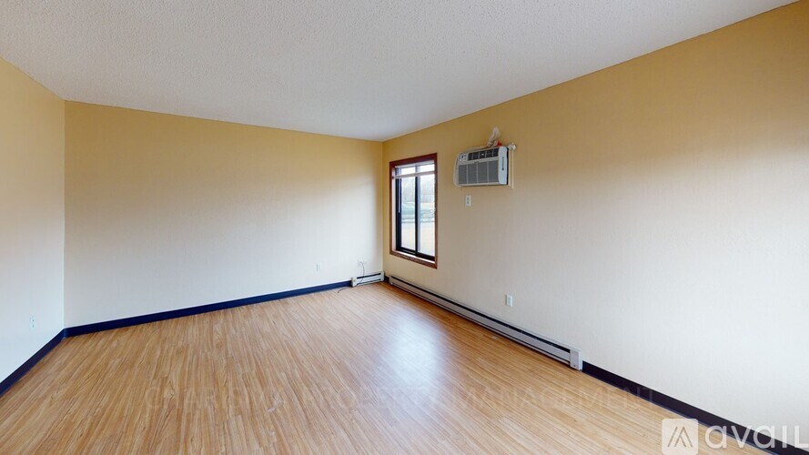 A room with wooden flooring and a window.