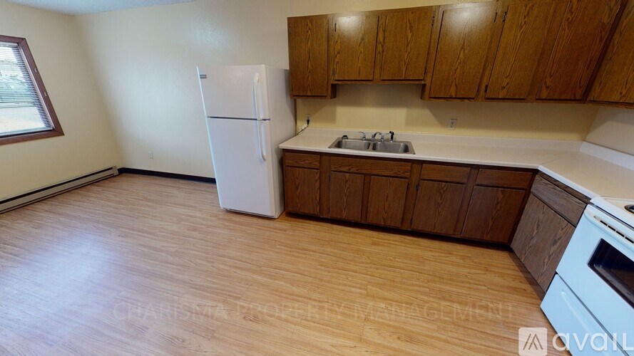 A kitchen with wooden cabinets and a white fridge.