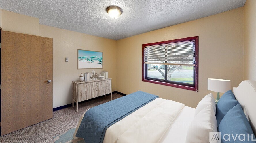 A bedroom with a bed, nightstand, and window.