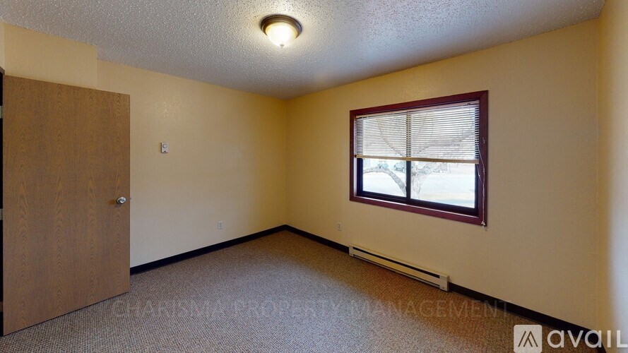 A room with a window and a door is available for rent.