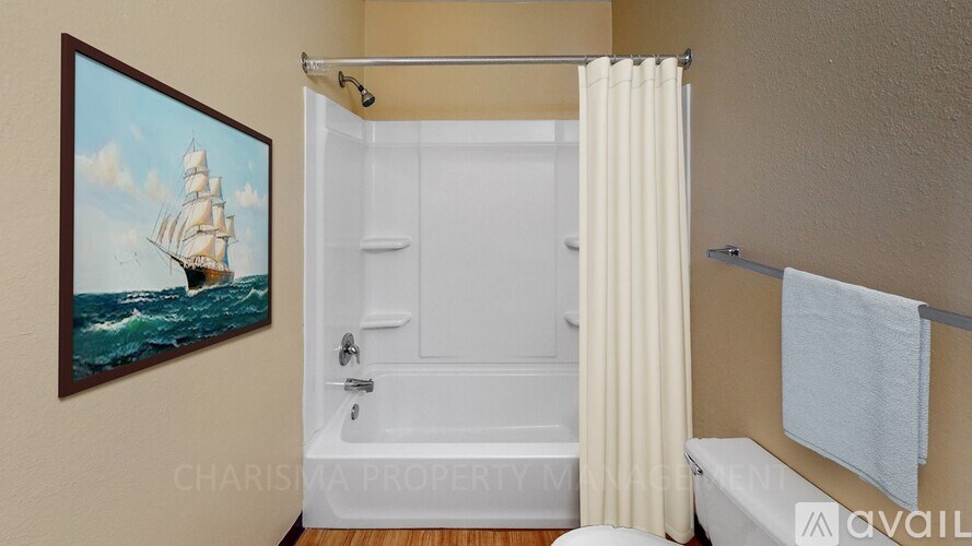 A bathroom with a ship painting on the wall.