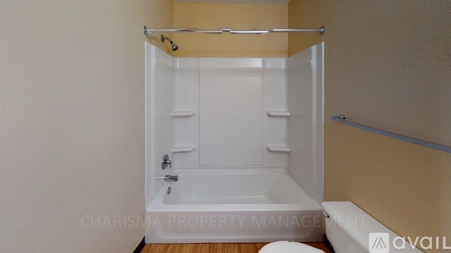 A white bathtub in a bathroom with a towel rack above it.