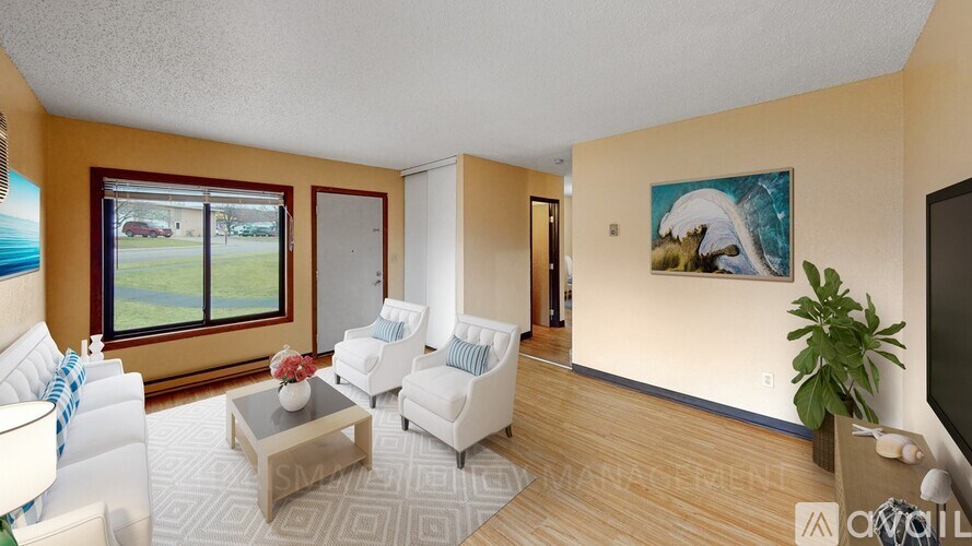 A living room with a white sofa, a coffee table, and a painting on the wall.