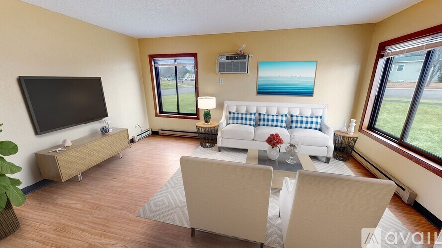 A living room with a white couch and a television.