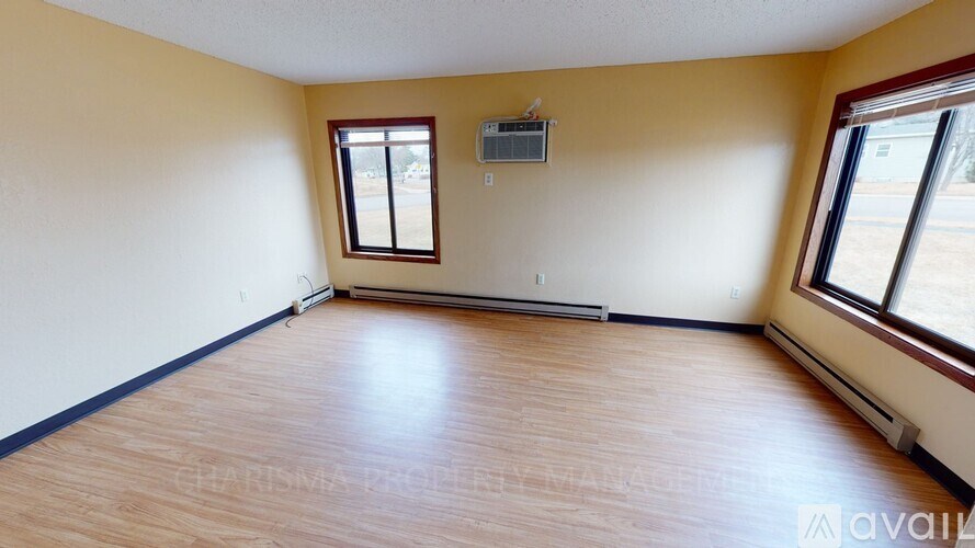 A room with wooden flooring and a window.