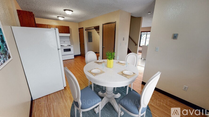 A dining room with a white table and chairs.