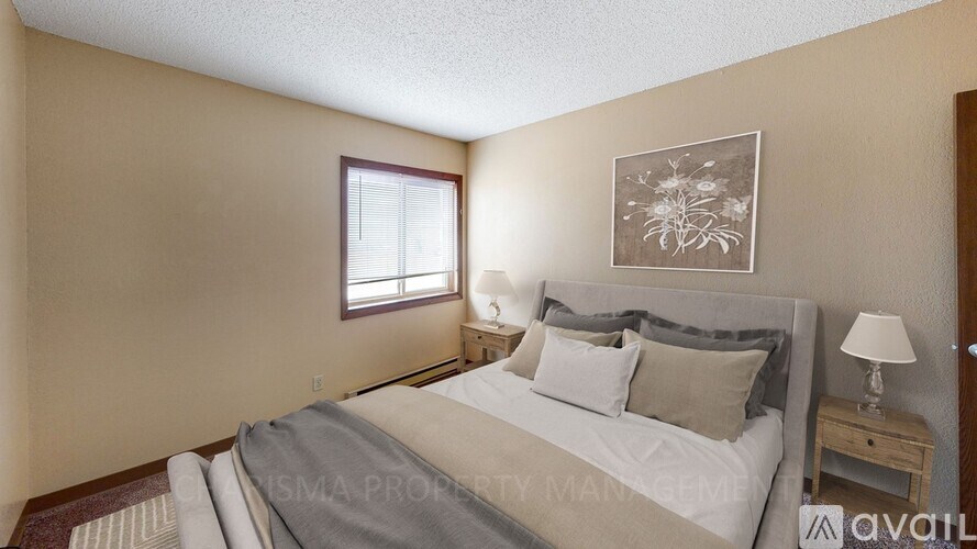 A bedroom with a large bed and a window with blinds.