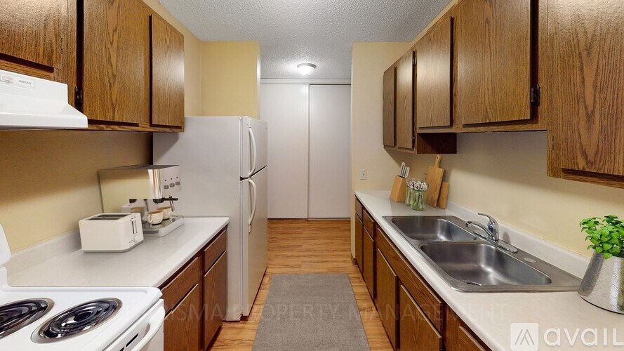 A kitchen with wooden cabinets and a white toaster on the counter.