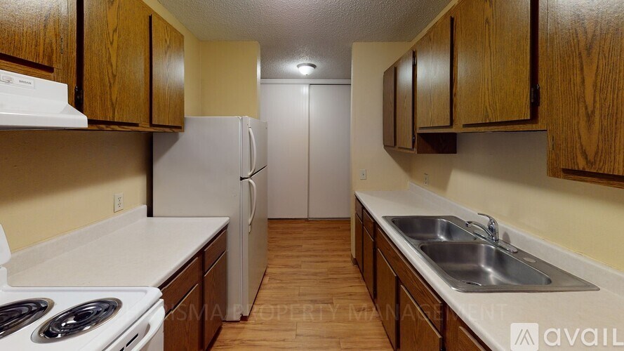 A kitchen with white appliances and wooden cabinets.