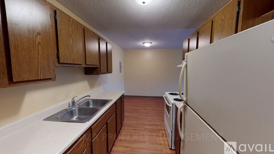 A kitchen with wooden cabinets and a white fridge.