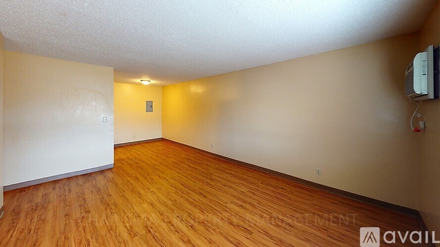 A room with wooden flooring and white walls.