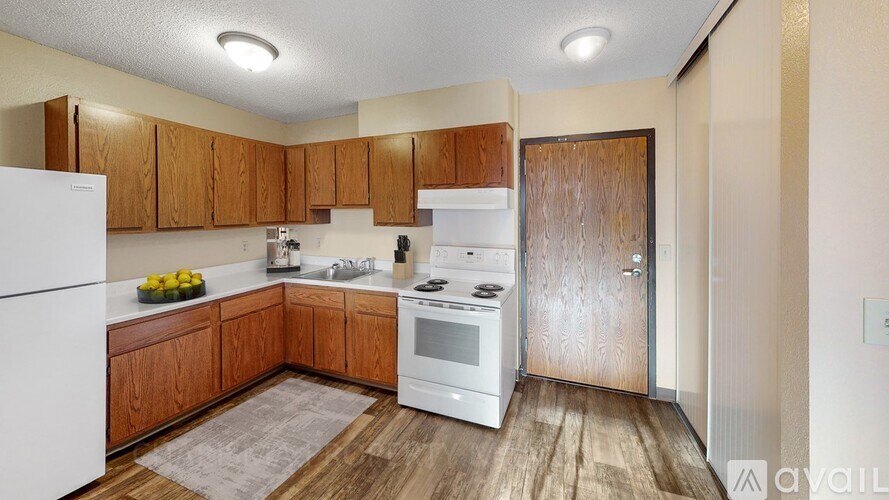 A kitchen with wooden cabinets and white appliances.