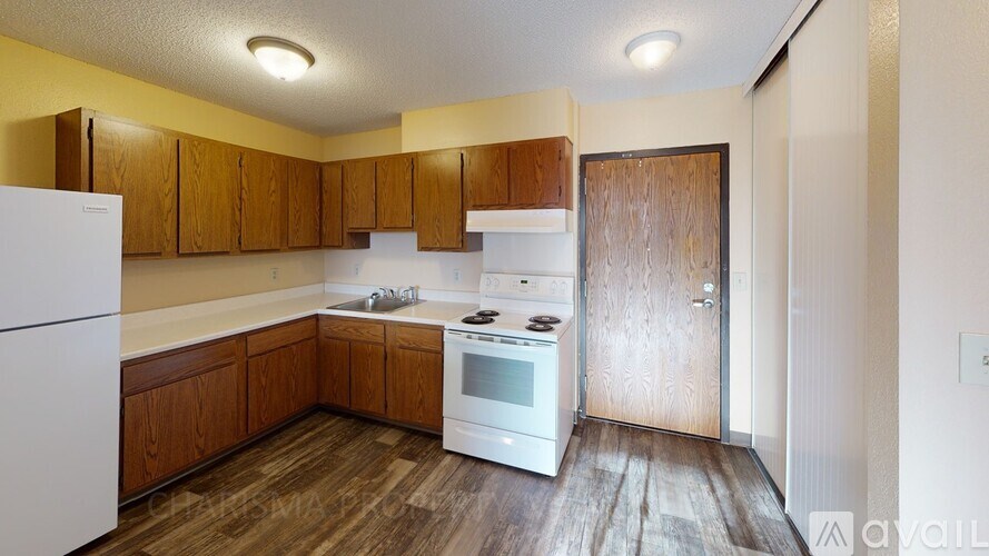 A kitchen with wooden cabinets and a white fridge.