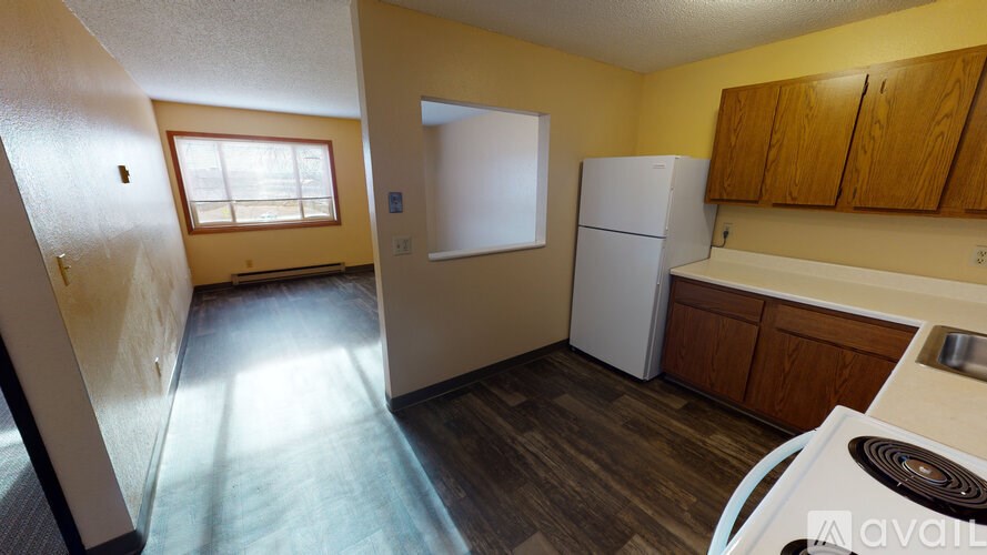 A kitchen with a white refrigerator and wooden cabinets.