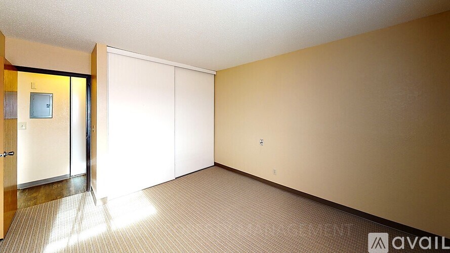 A room with a carpeted floor and a door on the left side.