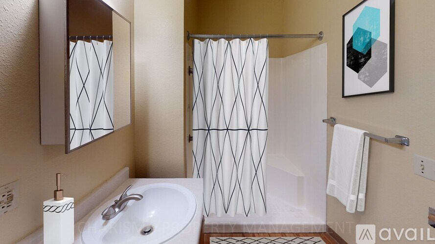 A bathroom with a white sink and a shower with a glass door.