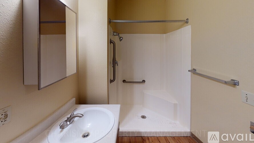 A bathroom with a sink, mirror, and shower.
