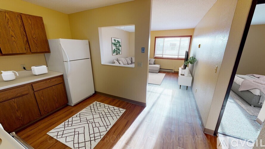 A kitchen with a white fridge and wooden cabinets.