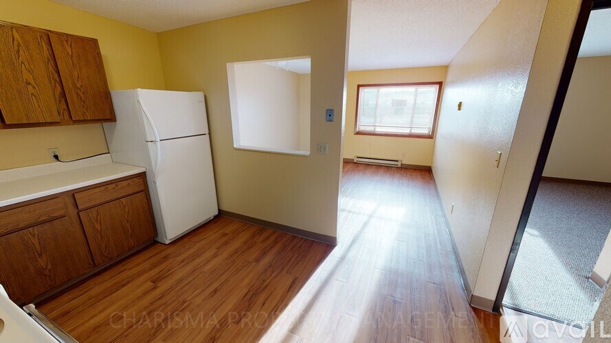 A kitchen with wooden cabinets and a white refrigerator.