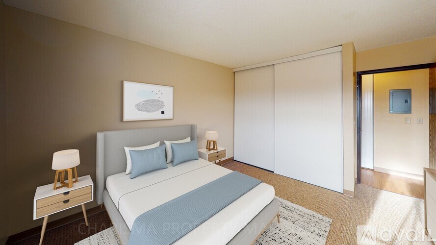 A bedroom with a bed, nightstand, and a painting on the wall.