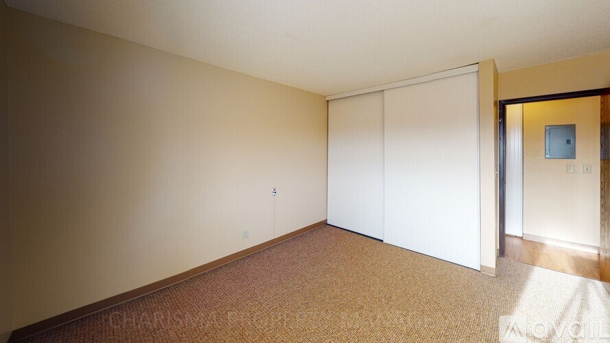 A room with a carpeted floor and a white door.