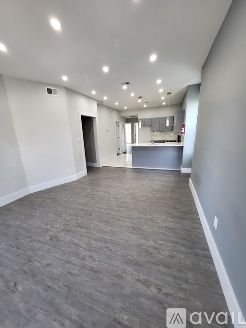 A spacious room with grey flooring and white walls.