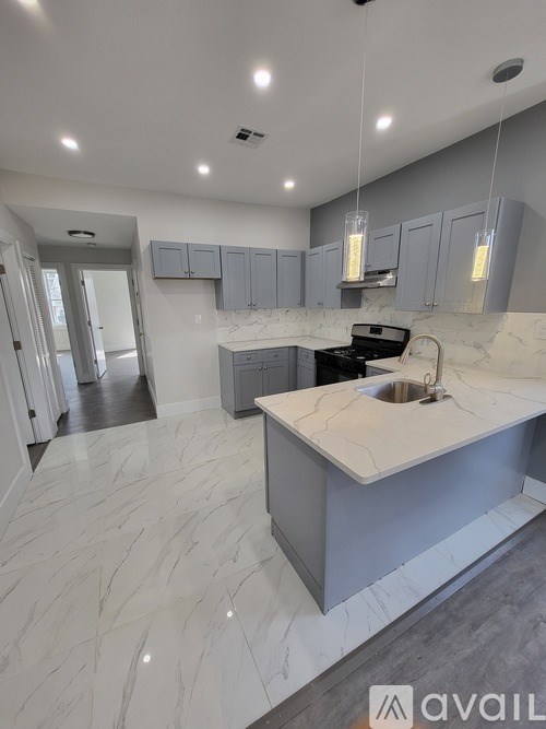 A modern kitchen with a marble countertop and a sink.