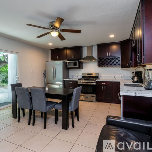A kitchen with a table and chairs.