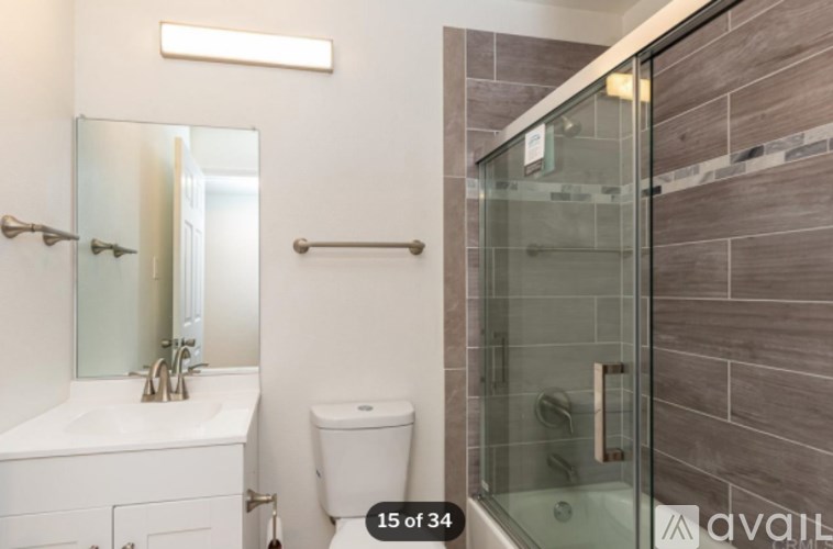 A bathroom with a toilet, sink, and shower.