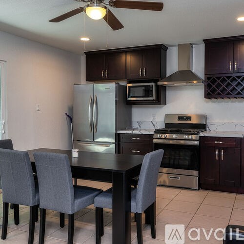 A kitchen with a table and chairs.