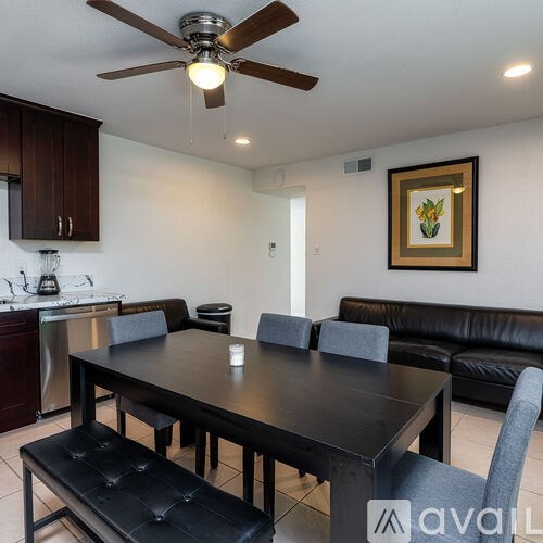 A modern dining room with a black table and chairs.