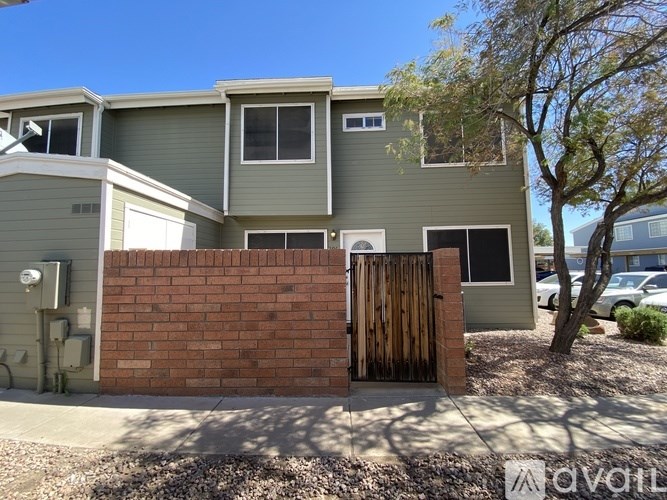 A house with a grey exterior and a brown wooden gate.