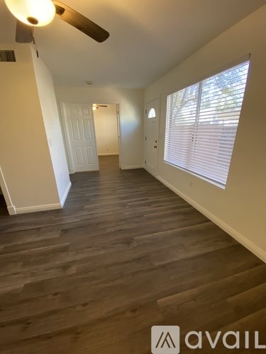 A room with wooden flooring and a ceiling fan.