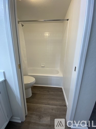 A small white bathroom with a toilet and a bathtub.