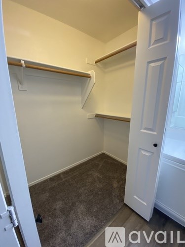 A small, empty room with a carpeted floor and a white door.