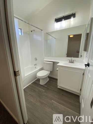 A bathroom with a toilet, sink, and mirror.