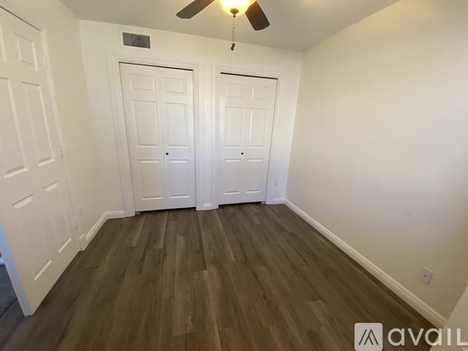 A room with two doors and a ceiling fan.