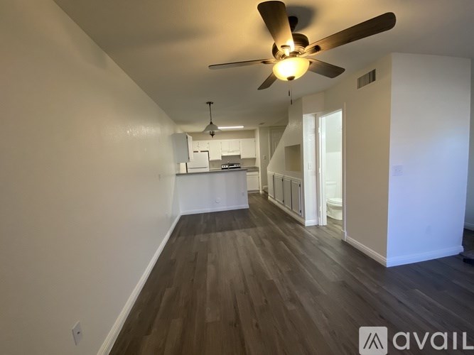 A spacious room with a ceiling fan and wooden flooring.
