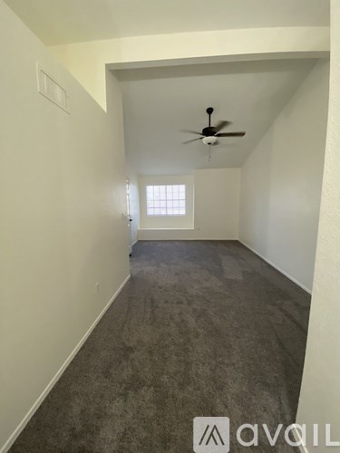 A room with a ceiling fan and a window.
